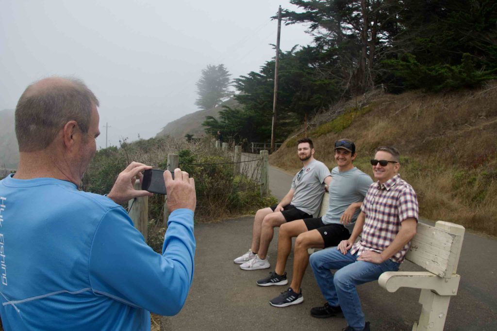 Brian, taking a picture of Matt, Michael and Tom on an invisible bench