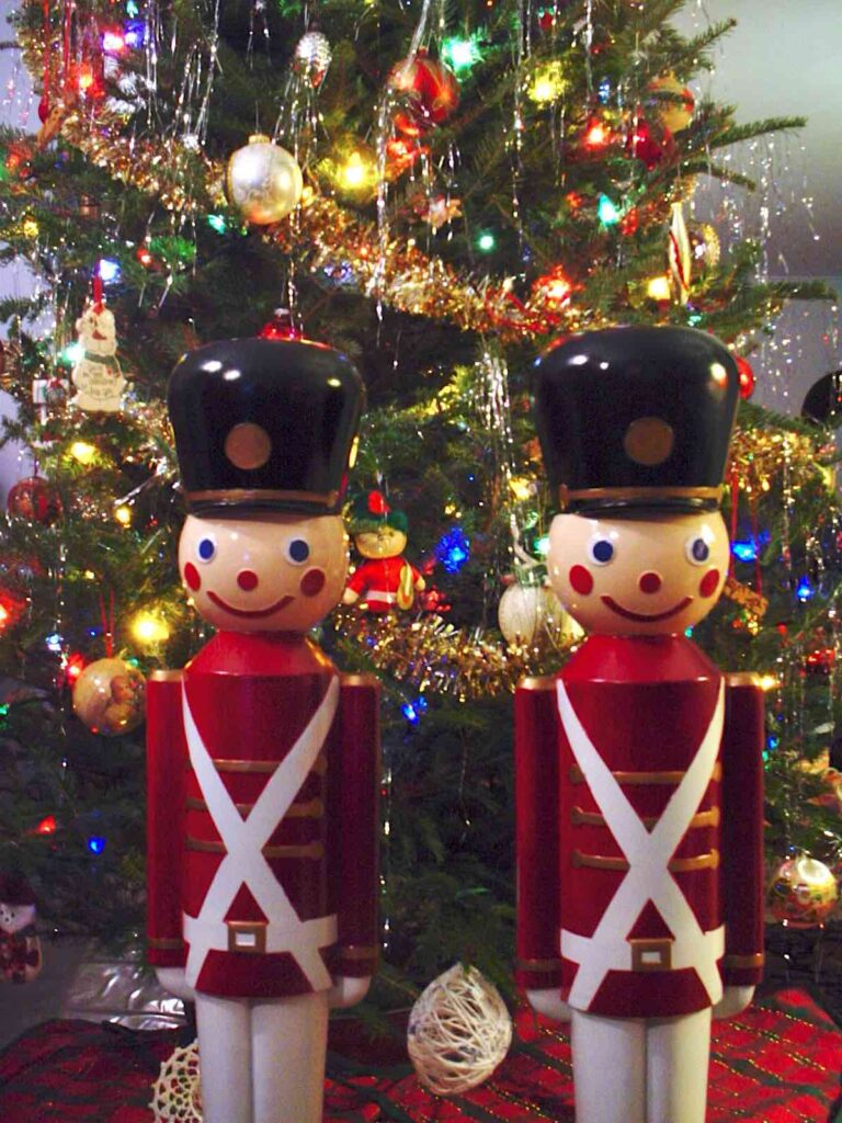 Two toy soldiers in front of decorated tree