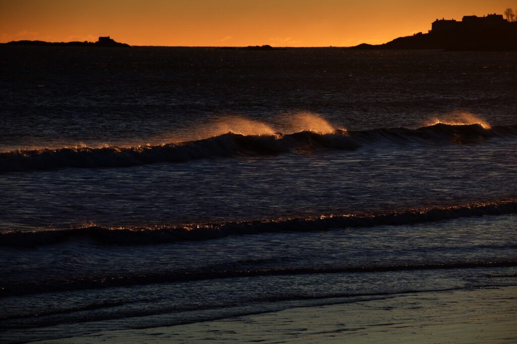 Wind blowing mist off the waves