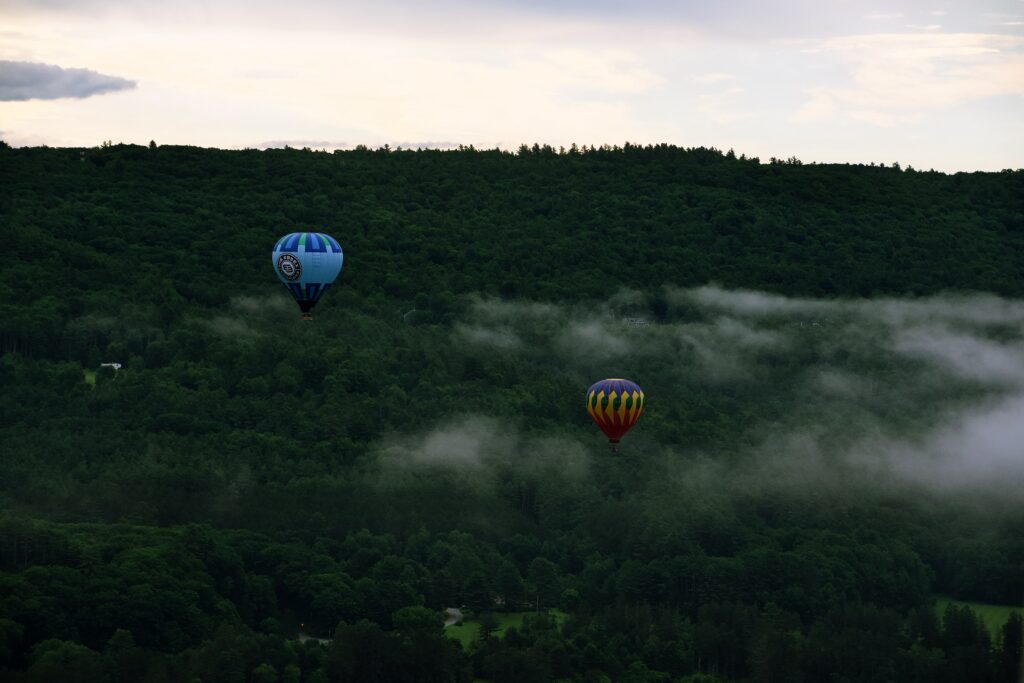 Balloons against foggy hillside